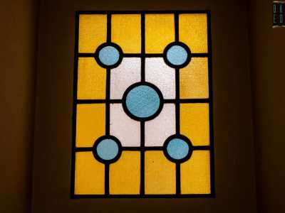 A colpirci di pi� � per� la porta che sancisce la fine dell�andito: � infatti sormontata da una vetrata in stile liberty che accosta figure geometriche blu e gialle, oltre le quali sembra celarsi una luce accecante